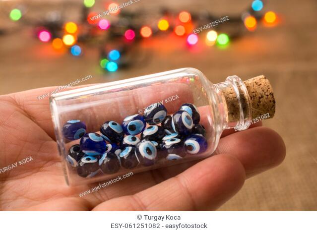 Hand holding Evil eye bead in bottle as souvenir