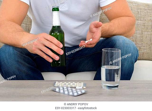Man Holding Pills And Bottle In Hand