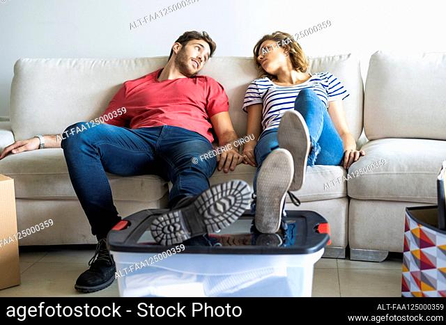 Young couple relaxing on sofa in their new house