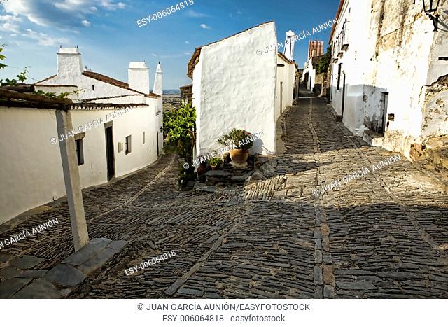 Magnificent village of Monsaraz; traditional street with small white houses and red tiles a typical view from the south of the country