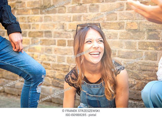 Group of young friends outdoors, young woman laughing