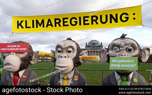 22 November 2021, Berlin: ""Climate Government"" is written in capital letters on a banner held by members of the environmental organization Greenpeace in front...