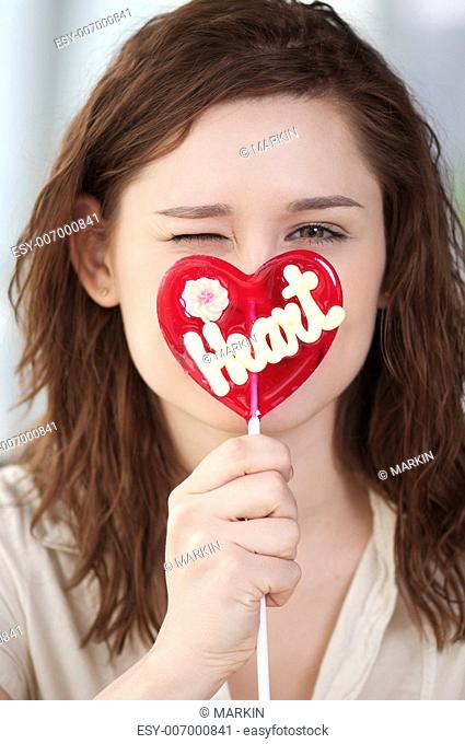 Portrait of pretty woman with candy heart. Love