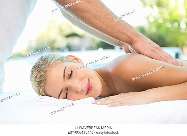 Woman receiving back massage at spa center