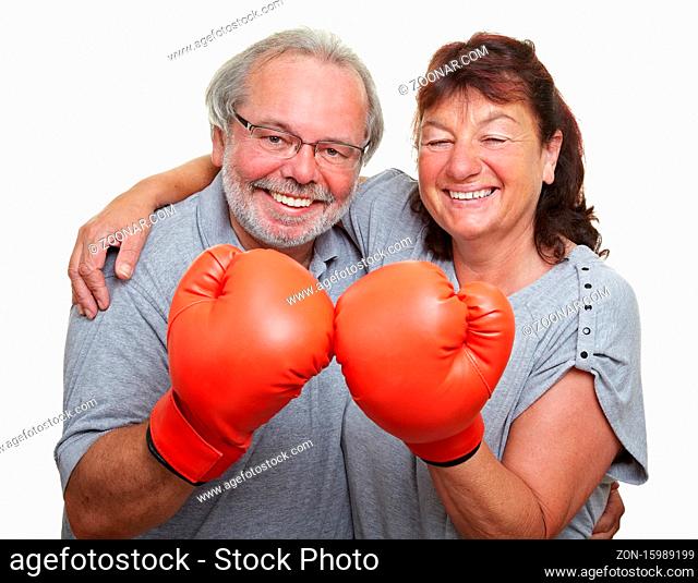 Lachendes Seniorenpaar gemeinsam mit zwei Boxhandschuhen