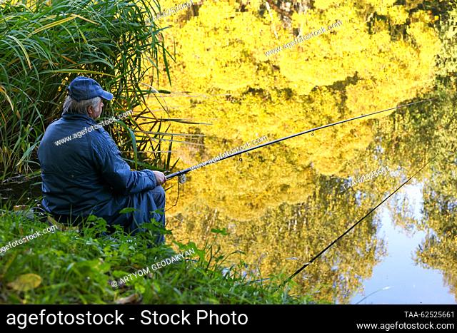 RUSSIA, MOSCOW - SEPTEMBER 23, 2023: A man fishes in a pond in the Tsitsin Main Moscow Botanical Garden of the Russian Academy of Sciences