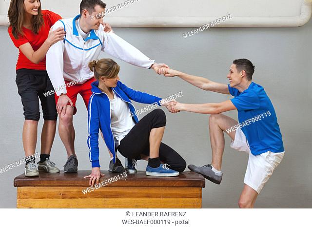 Germany, Berlin, Young men and women messing on vaulting horse