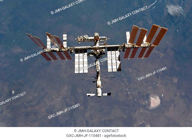 The International Space Station is featured in this image photographed by an STS-133 crew member on space shuttle Discovery after the station and shuttle began...
