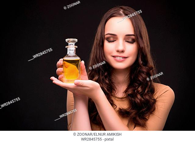 Young woman with bottle of perfume