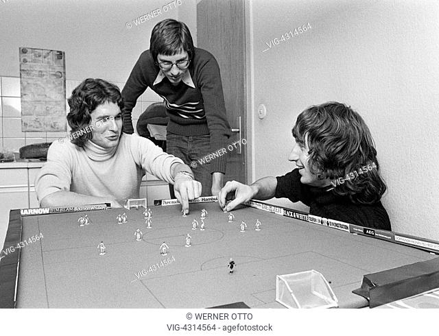 DEUTSCHLAND, OBERHAUSEN, STERKRADE, 02.12.1974, Seventies, black and white photo, people, three young men playing table football, freetime, hobby, long-haired