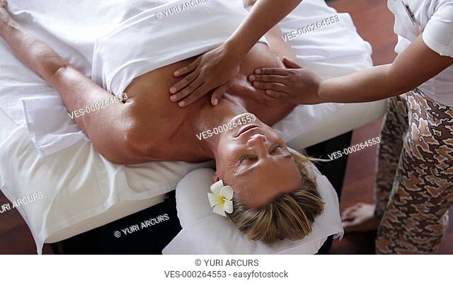 Topview of a mature woman receiving a relaxing chest and shoulder massage