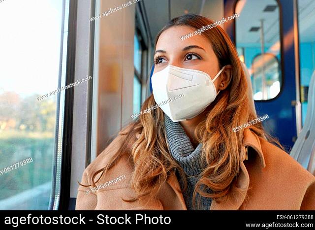 Close up of young lady wearing protective medical mask KN95 FFP2 on public transport looking through the window