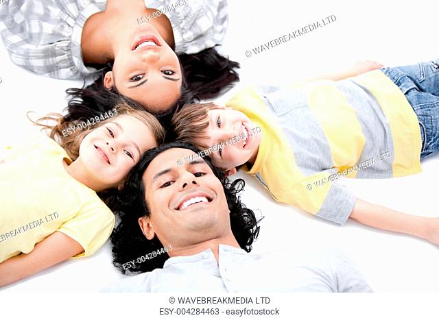 Smiling family lying on the floor together