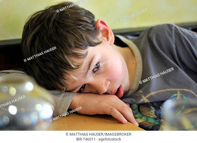 Boy, 9 years old, tired, bored, thoughtful