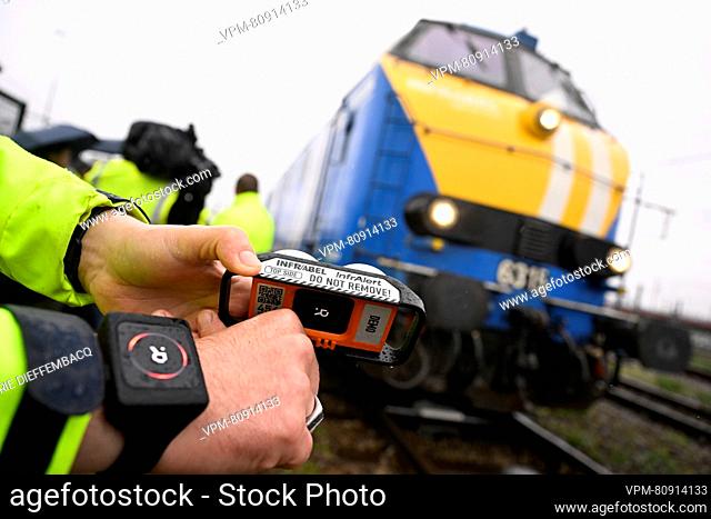 A worker demonstrates a wrist watch showing a notification a train is arriving, and the Infralert device at the presentation of two new safety systems of...