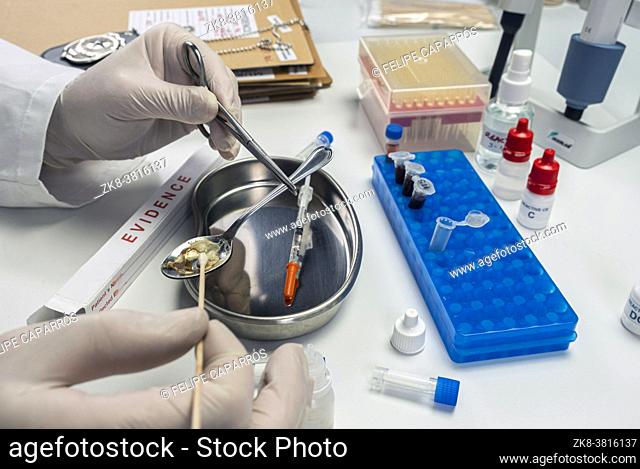 Police scientist holding spoon used in crime lab overdose case, conceptual image