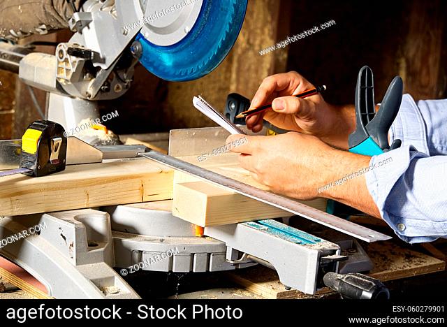 Carpenter work concept. Carpenter work with circular saw for cutting wood bar, the man sawed bars, construction and home renovation