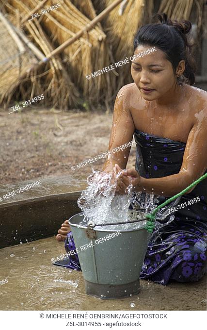 Woman bathing in small town well outside Bagan Myanmar