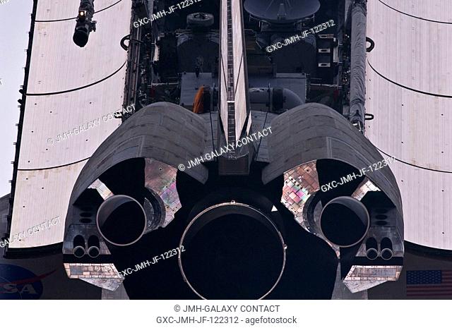 This view of the aft portion of gthe space shuttle Atlantis, including main engines, part of the cargo bay, vertical stabilizer and orbital maneuvering system...