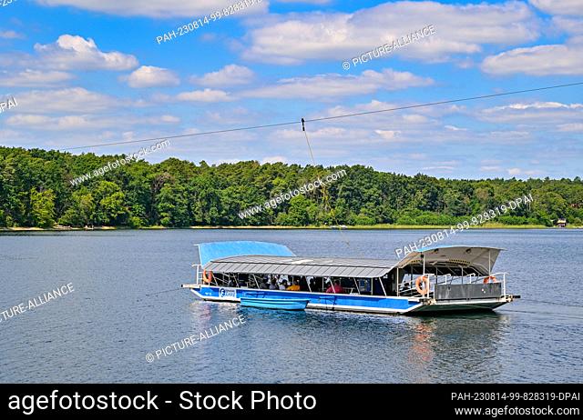 PRODUCTION - 11 August 2023, Brandenburg, Strausberg: A cable ferry crosses Lake Straus. The lake has lost half of its water for about ten years