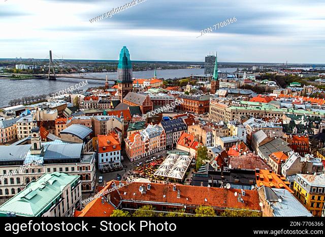 Top view of Riga, Latvia on the coastline of Daugava river with buildings around, on cloudy sky background