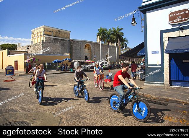Cyclists in front of the colonial buildings at the historic center, Merida, Riviera Maya, Yucatan State, Mexico, Central America