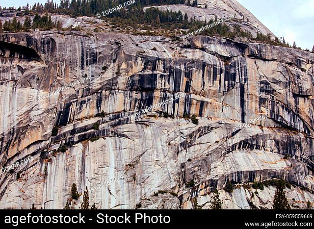 The view from within Yosemite Valley and rock detail of surrounding rock faces on a stormy day in California, USA