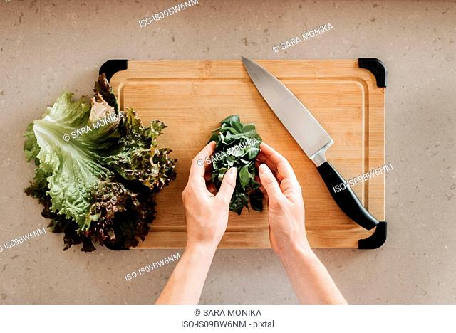 Woman preparing salad on cutting board