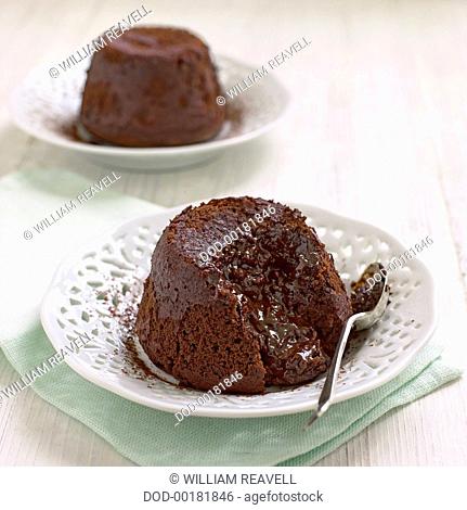 Chocolate fondant served on white dishes with spoon, close-up