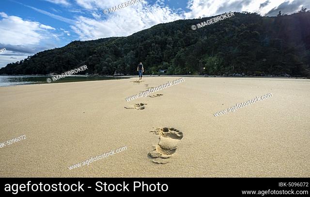 Footprints in the sand, Young man on the beach of Stillwell Bay, Abel Tasman National Park, Tasman, South Island, New Zealand, Oceania
