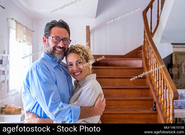 Happy caucasian couple embracing each other in the living room. Loving husband and wife hugging at home. Profile of affectionate man and woman spending leisure...