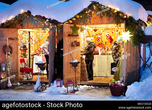 romantic christmas market in Bavaria with illuminated and decorated wooden huts in snow
