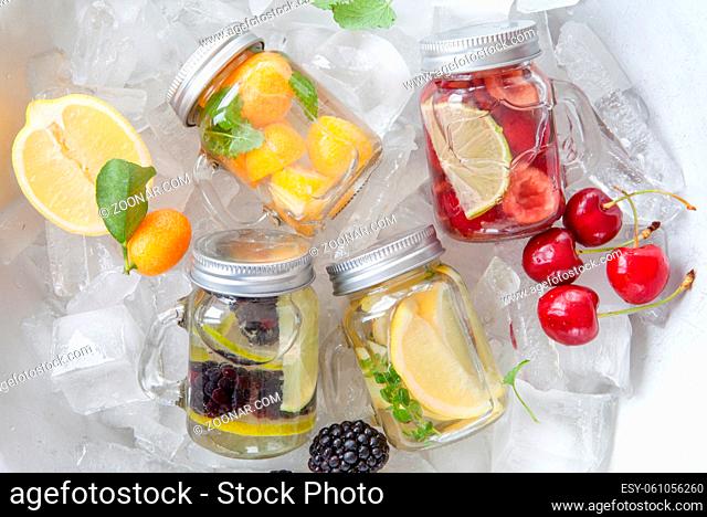 Frisches Wasser mit bunten Fruechten in kleinen Einmachglaesern