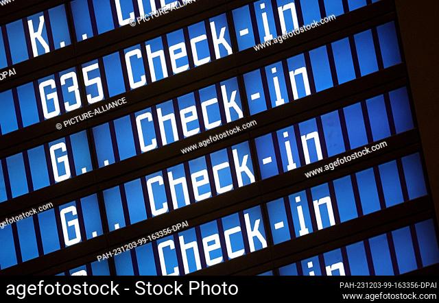03 December 2023, Bavaria, Munich: ""Check-in"" can be read on an electronic display board at Munich Airport. Munich Airport resumed flight operations at 06:00...