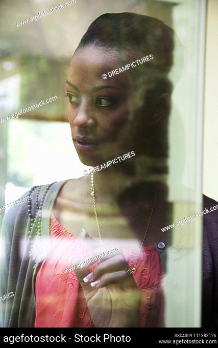 Black woman looking through window