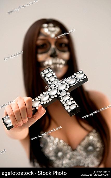 Santa Muerte halloween look. Close-up of cross with rhinestones