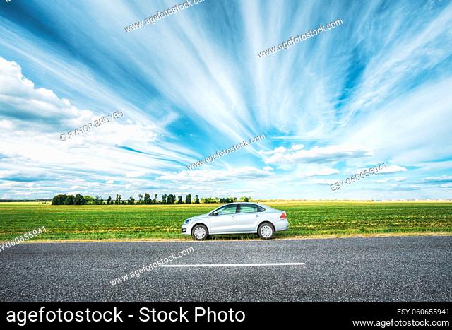 Gomel, Belarus - June 13, 2016: Volkswagen Polo Car Parking On A Roadside Of Country Road On A Background Of Green Spring Fields Or Meadow In Sunny Day With A...