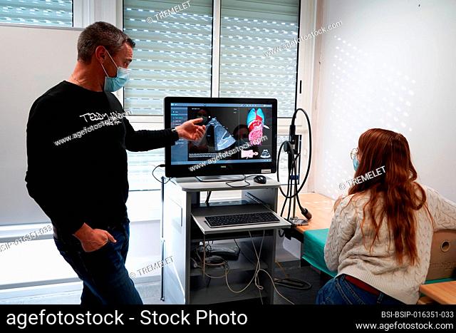 Students and their teacher during an echography simulation workshop on a robot mannequin