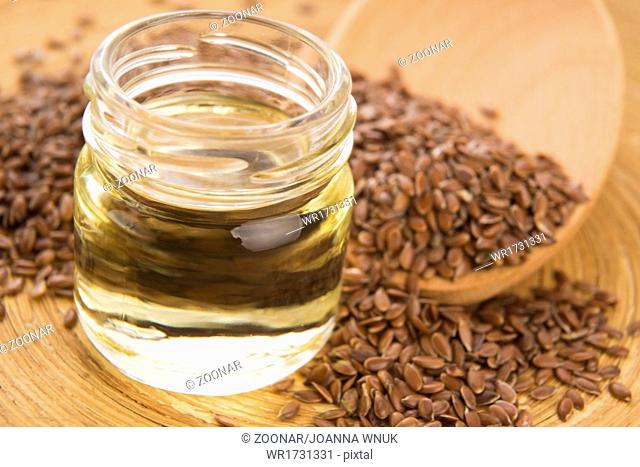 Linseed oil and flax seeds on wooden background