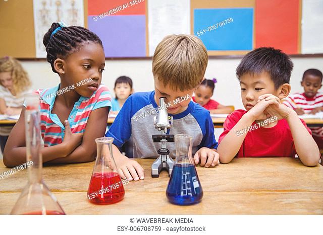 Cute pupil looking through microscope