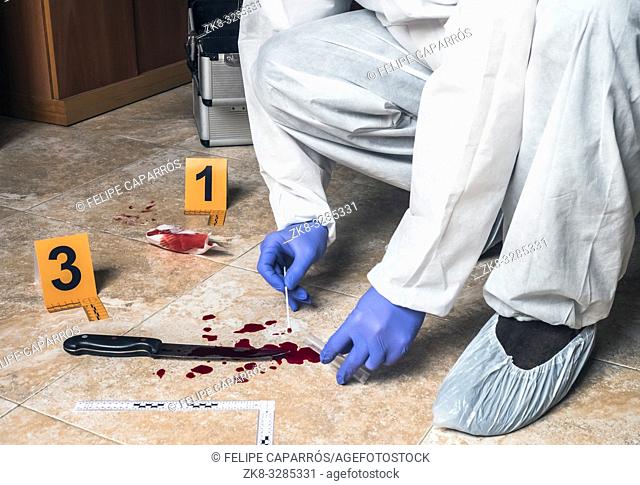 Expert Police takes blood sample from a blood knife at the scene of a crime, conceptual image