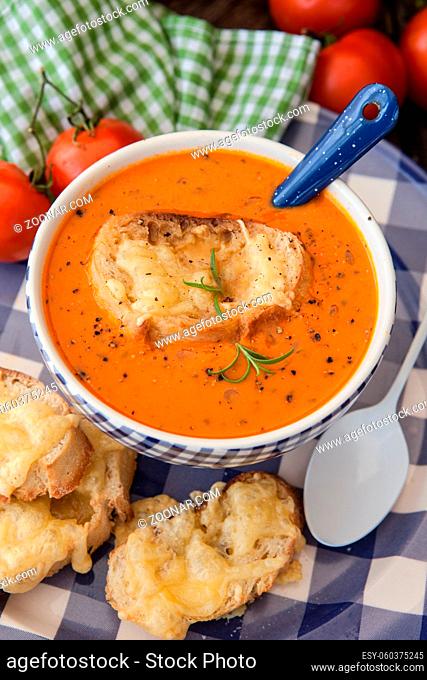 Herzhafte Tomatensuppe mit Käse überbackenem Baguette