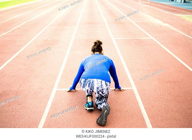 Female athlete training for race in stadium
