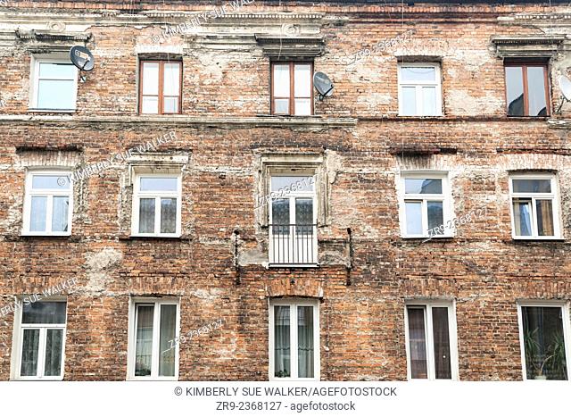 Exterior of an occupied brick apartment building left over from Communist time period when all decorations were removed, symbolizing a move against capitalism