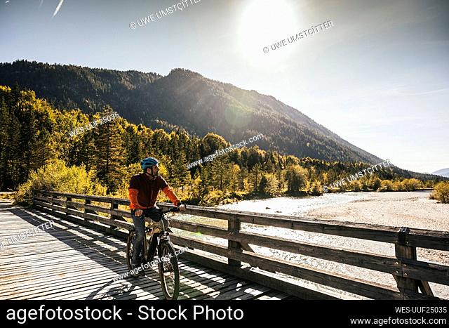 Man riding mountain bike on sunny day