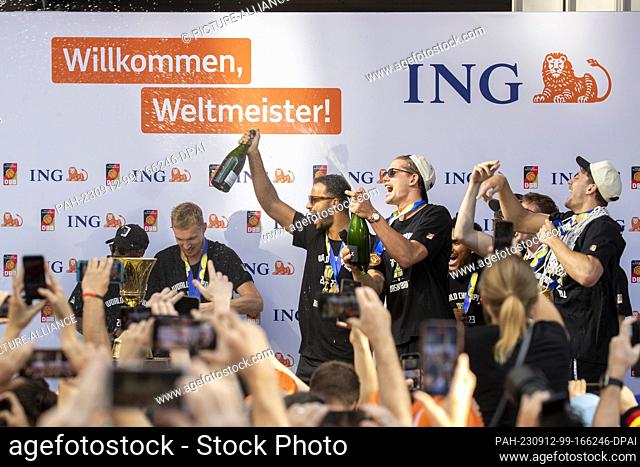 12 September 2023, Hesse, Frankfurt/Main: The team lets the corks pop on stage at the reception in Frankfurt. The DBB national team won the World Cup final...