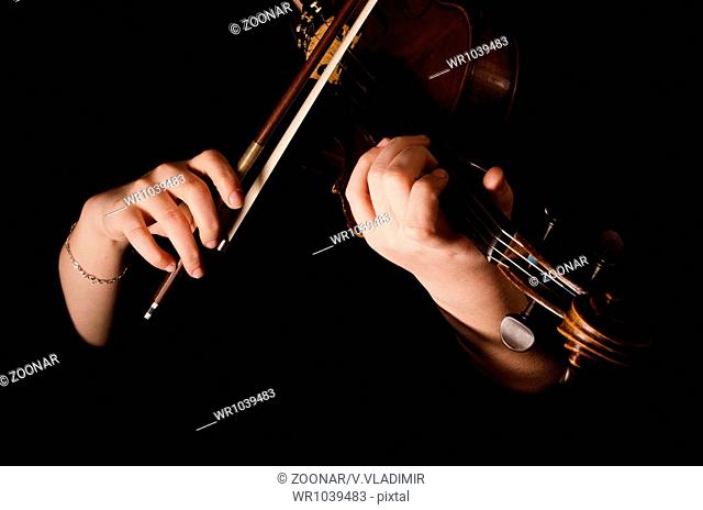 Female hands play a violin on the black
