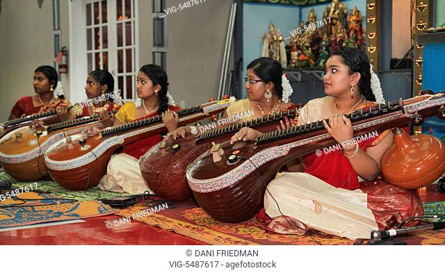 Tamil Hindu girls perform a devotional song on the veena during the Mancham Narayanan Perumaal Festival (which honours Lord Vishnu) at a Tamil Hindu temple in...