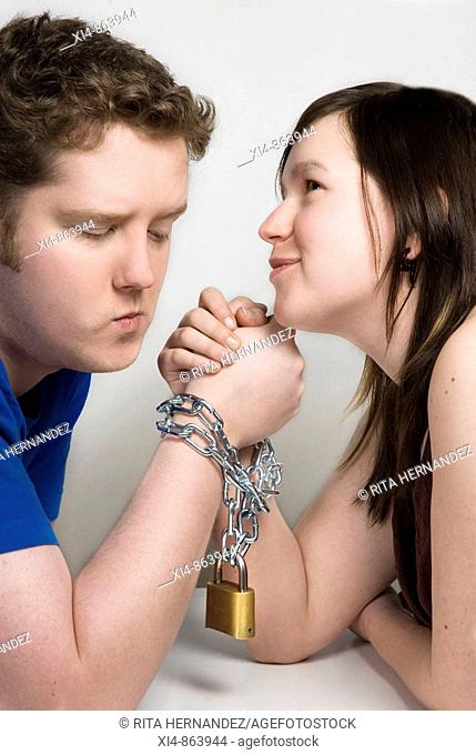 Couple holding hands with chain linking them