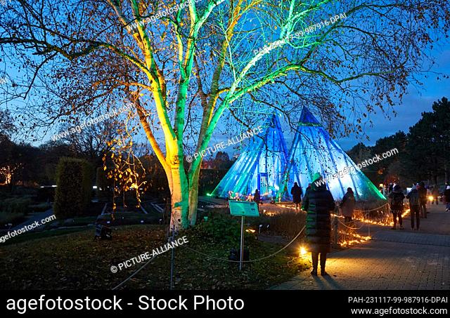17 November 2023, Hamburg: The first visitors walk past light installations in the ""Christmas Garden"" in the Loki-Schmidt-Garten